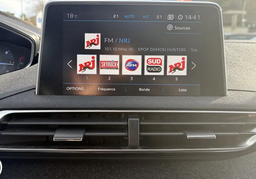 Écran tactile central du Peugeot 3008 II 2019 affichant les radios FM avec commandes de climatisation et aérateurs noirs.