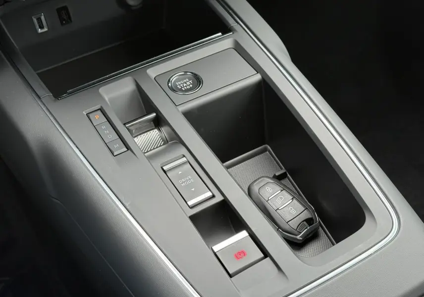 Vue rapprochée de la console centrale grise du Citroën C5 Aircross 2025 avec boîte auto et clé électronique posée.