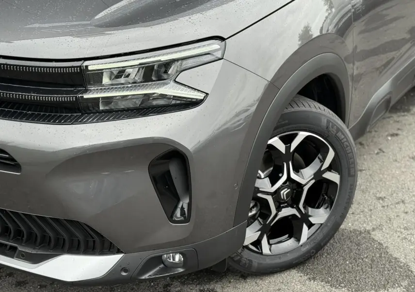 Gros plan sur l'avant droit gris Platinium du Citroën C5 Aircross 2025 avec phares LED et jante alliage 18'' bi-ton.