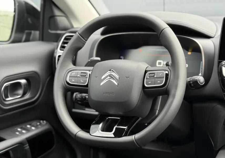 Vue rapprochée du volant cuir noir avec commandes intégrées du Citroën C5 Aircross, intérieur Urban Black.