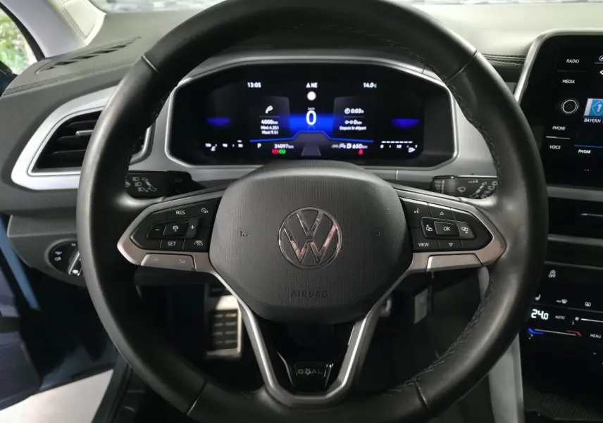 Volant en cuir noir avec logo Volkswagen, vue frontale sur le tableau de bord digital du T-Roc bleu 2025.