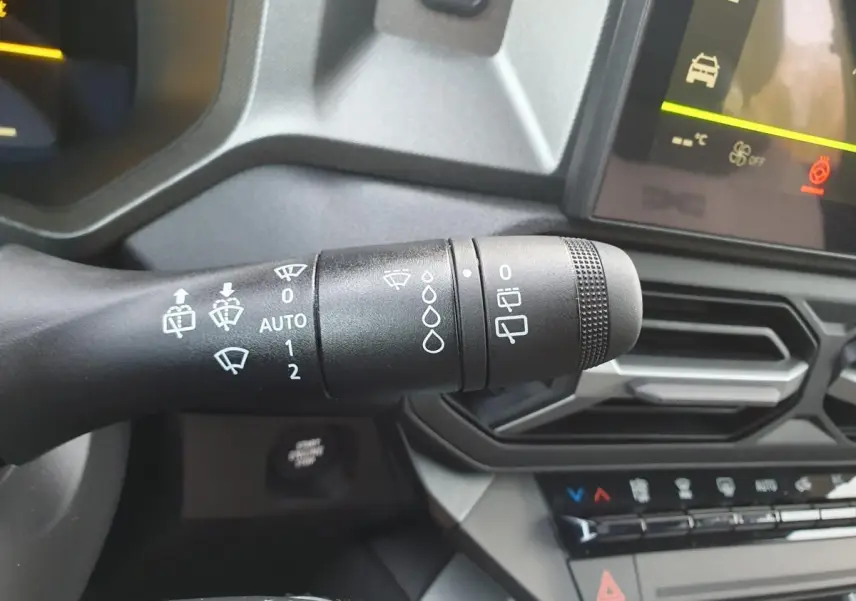Gros plan sur la commande d’essuie-glace côté droit du tableau de bord du Dacia Bigster 2026 noir Perla.