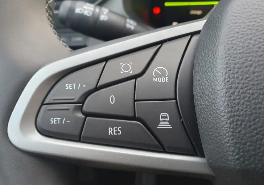 Gros plan sur les commandes au volant côté gauche du Dacia Bigster 2026 noir Perla, avec boutons de régulateur et mode conduite.