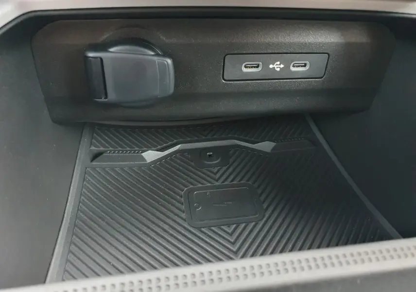 Gros plan sur la console centrale du Dacia Bigster noir Perla, montrant deux ports USB-C et un chargeur à induction.