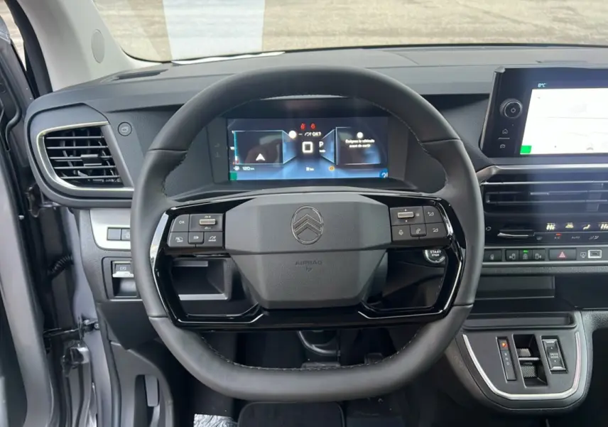 Vue intérieure centrée sur le volant cuir multifonctions et le tableau de bord numérique du Citroën Spacetourer gris acier.