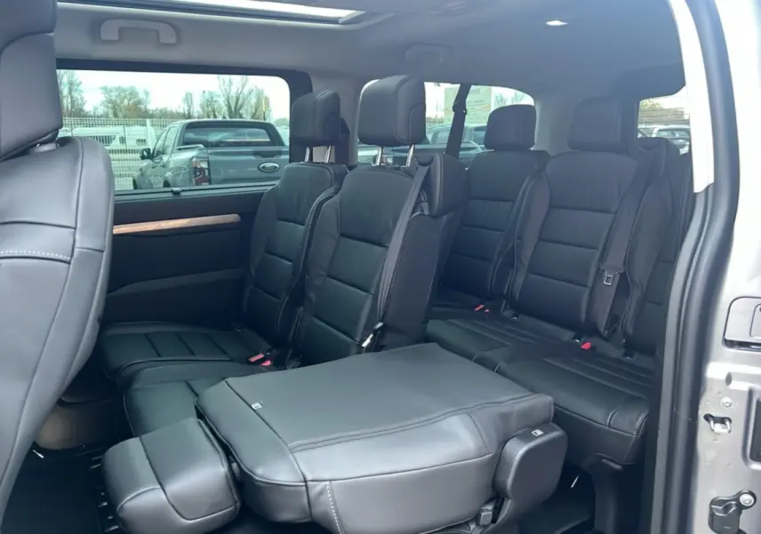 Intérieur du Citroën Spacetourer XL gris acier vu côté droit, sièges cuir noirs 8 places avec porte latérale ouverte.