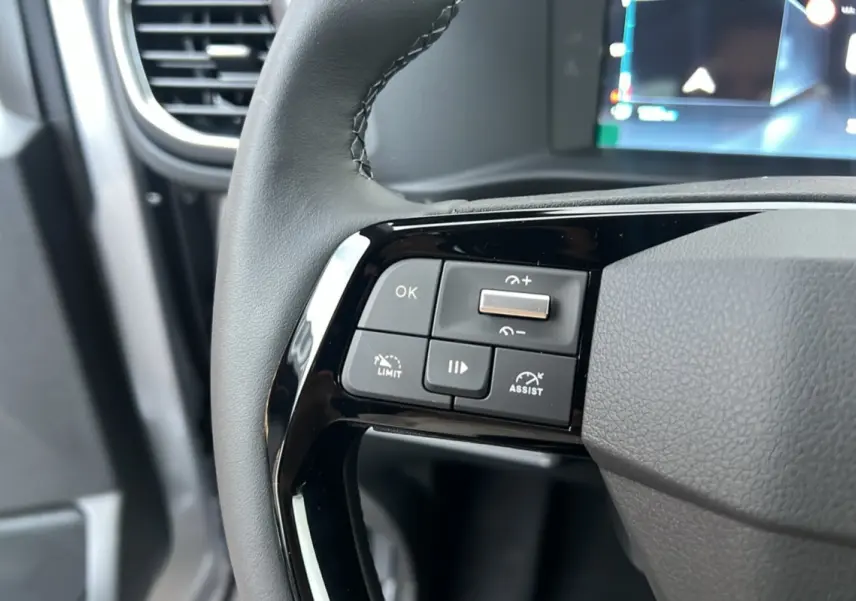 Gros plan sur les commandes multifonctions à gauche du volant cuir noir du Citroën Spacetourer gris acier 2025.