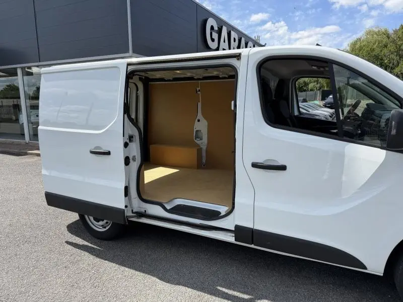Vue latérale droite d’un Renault Trafic Fourgon blanc Glacier 2024 avec porte coulissante ouverte montrant l’espace de chargement vide.