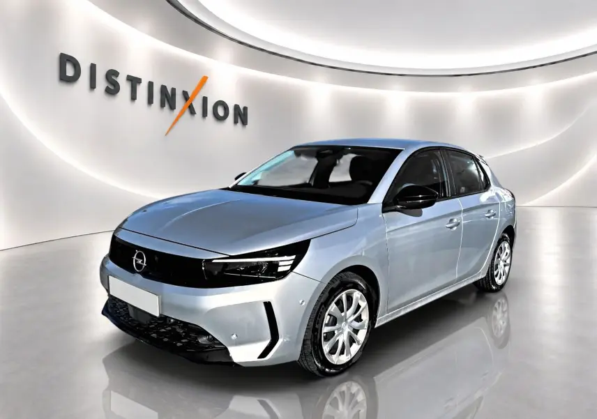 Opel Corsa gris 3/4 avant droit dans un showroom lumineux avec logo Distinxion en arrière-plan.