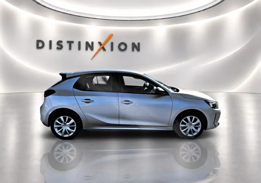 Opel Corsa 2025 gris en profil droit dans un showroom avec logo Distinxion en arrière-plan.