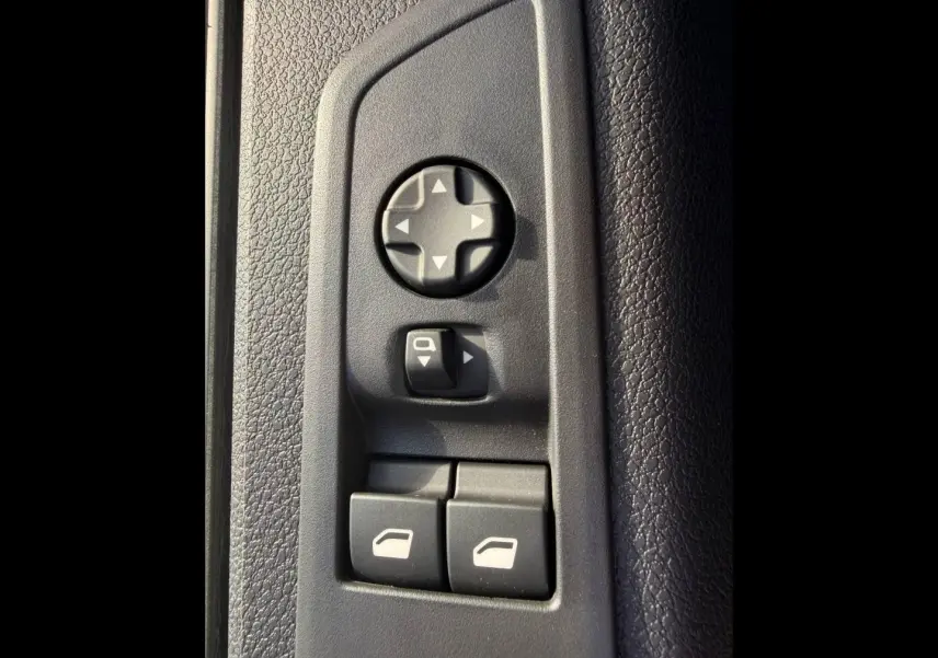 Gros plan sur les commandes de réglage des rétroviseurs et des vitres côté conducteur du Citroën Spacetourer noir.