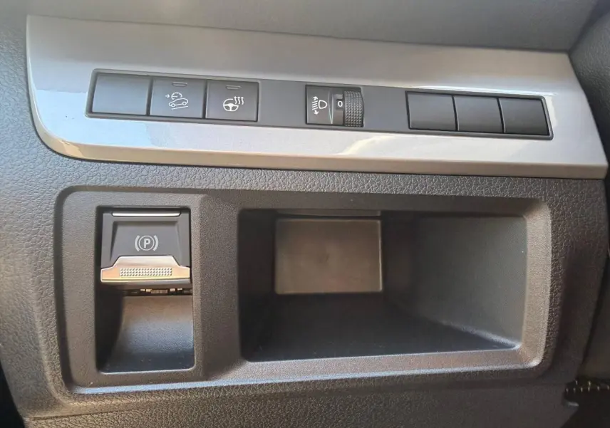 Gros plan sur les commandes de régulateur de vitesse et frein de stationnement électrique du tableau de bord du Citroën Spacetourer XL noir.
