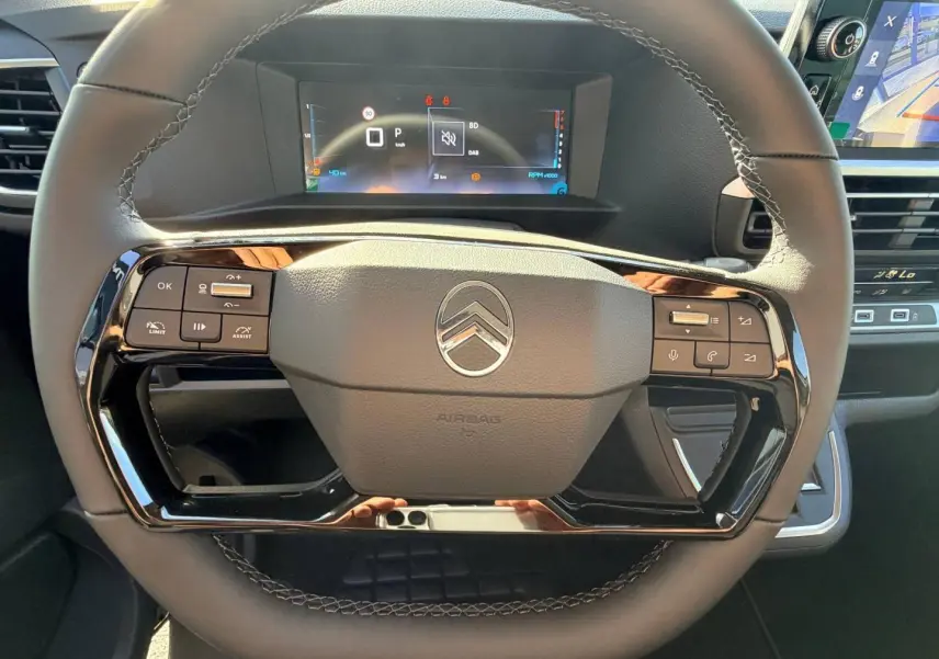 Vue rapprochée du volant noir mat de la Citroën Spacetourer avec commandes intégrées et tableau de bord numérique.