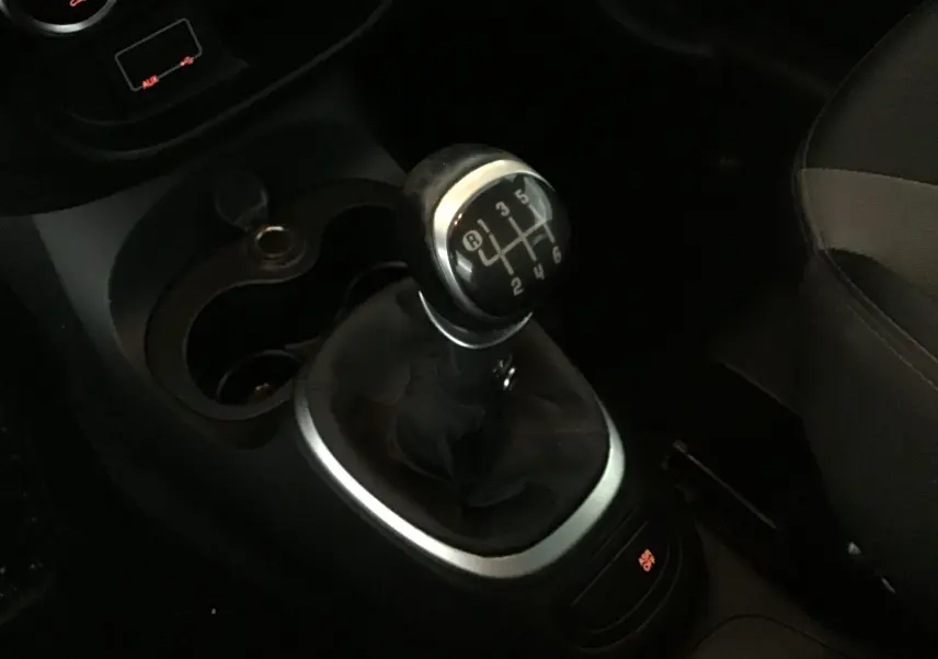 Le levier de vitesse manuel de la FIAT 500L 1.6 MJT 105 Lounge 7 places, avec console noire et sièges gris.