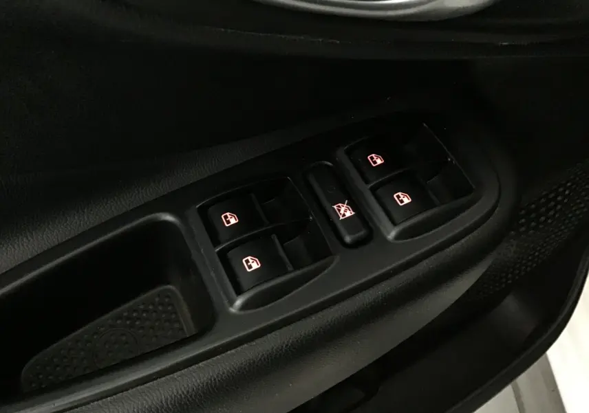 Gros plan sur les commandes des vitres électriques côté conducteur d'une FIAT 500L blanche de 2015.
