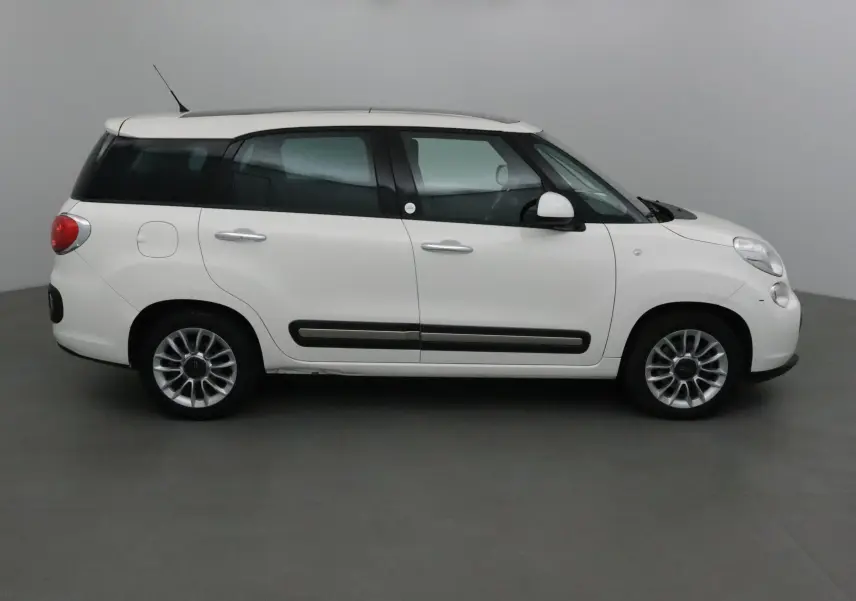 Profil droit d'un FIAT 500L blanc de 2015 avec lunette arrière surteintée et jantes alliage 16 pouces.