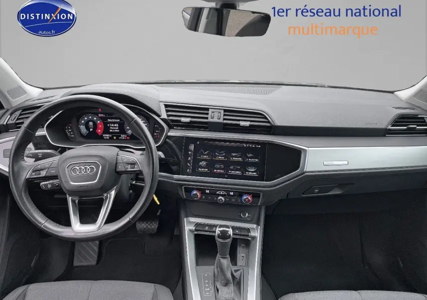 Vue intérieure avant de l'Audi Q3 35 TFSI 2019, tableau de bord moderne avec écran tactile et volant multifonction noir.