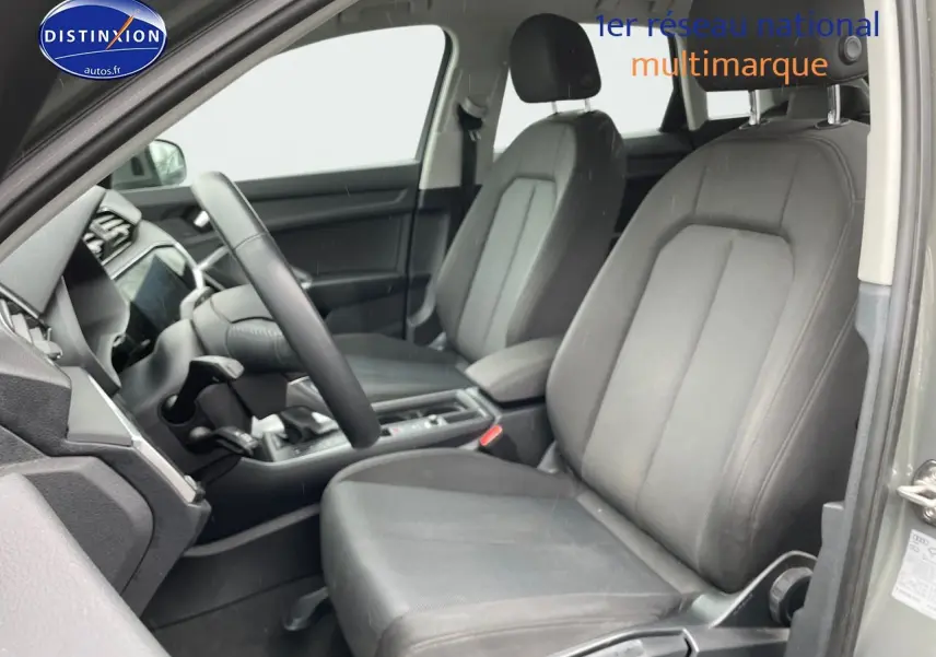 Vue intérieure côté conducteur de l'Audi Q3 35 TFSI 2019 avec sièges tissu gris et tableau de bord moderne.