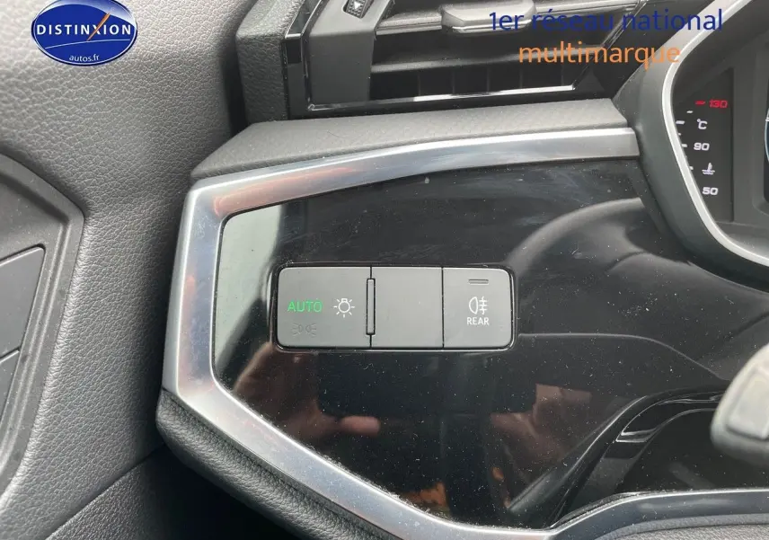 Gros plan sur les commandes d’éclairage à gauche du tableau de bord de l’Audi Q3 gris Chronos 2019.