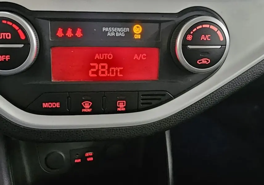 Détail du tableau de bord de la KIA PICANTO II 2016 montrant la climatisation automatique réglée à 28°C.