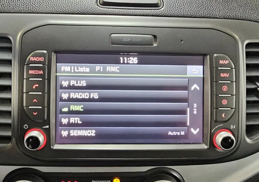 Écran central tactile de la Kia Picanto II 2016 affichant la liste des stations radio avec commandes autour.