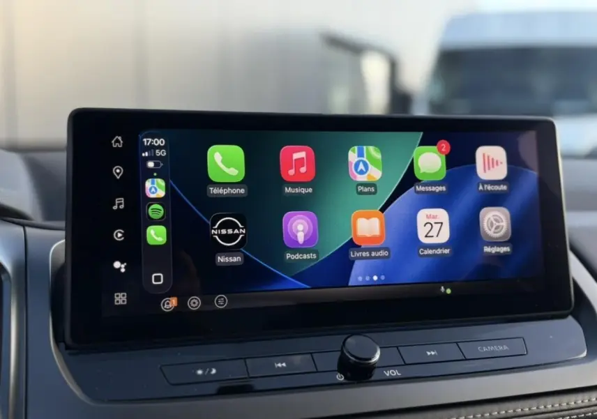 Écran tactile central du Nissan Qashqai 2025 affichant Apple CarPlay avec icônes colorées sur fond noir.
