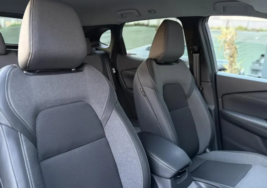 Vue intérieure montrant les sièges avant gris et noirs du Nissan Qashqai III e-Power avec accoudoir central.