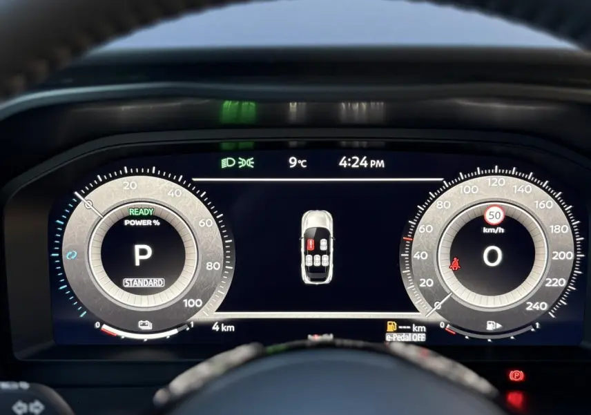 Affichage numérique du tableau de bord du Nissan Qashqai gris, montrant la vitesse à 0 km/h et l'heure à 16h24.