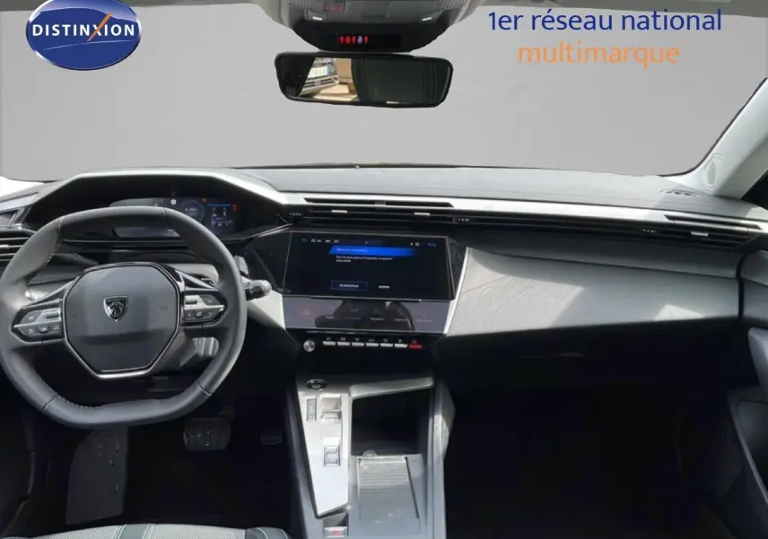 Vue intérieure avant du Peugeot 308 SW Hybrid 2025 avec tableau de bord noir et écran tactile central lumineux.