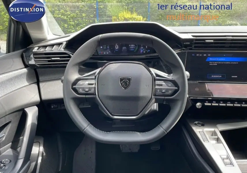Vue intérieure centrée sur le volant cuir noir et le tableau de bord numérique de la Peugeot 308 SW Hybrid 2025.