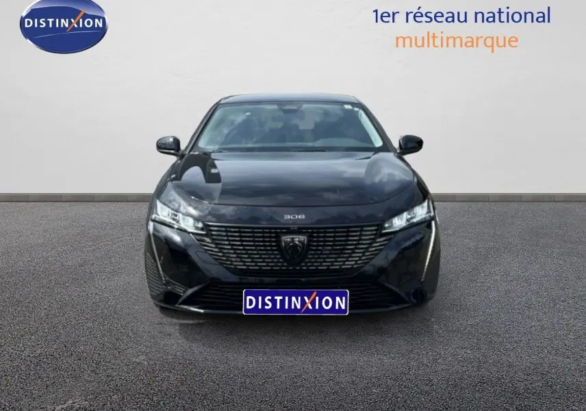 Vue frontale d'une Peugeot 308 SW Hybrid 145ch Allure noire métal avec calandre distinctive et phares LED fins.
