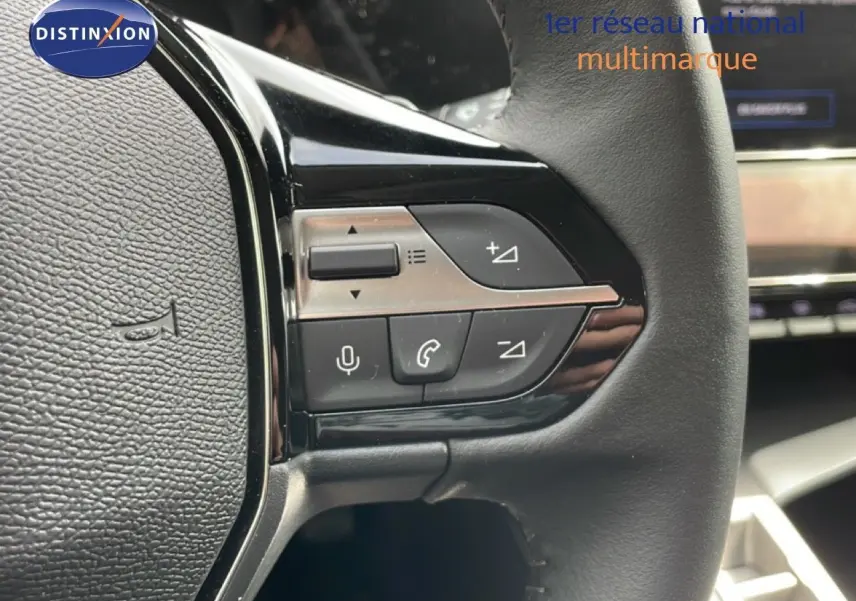 Gros plan sur les commandes multifonctions du volant cuir noir du Peugeot 308 SW Hybrid 2025, finition Allure.