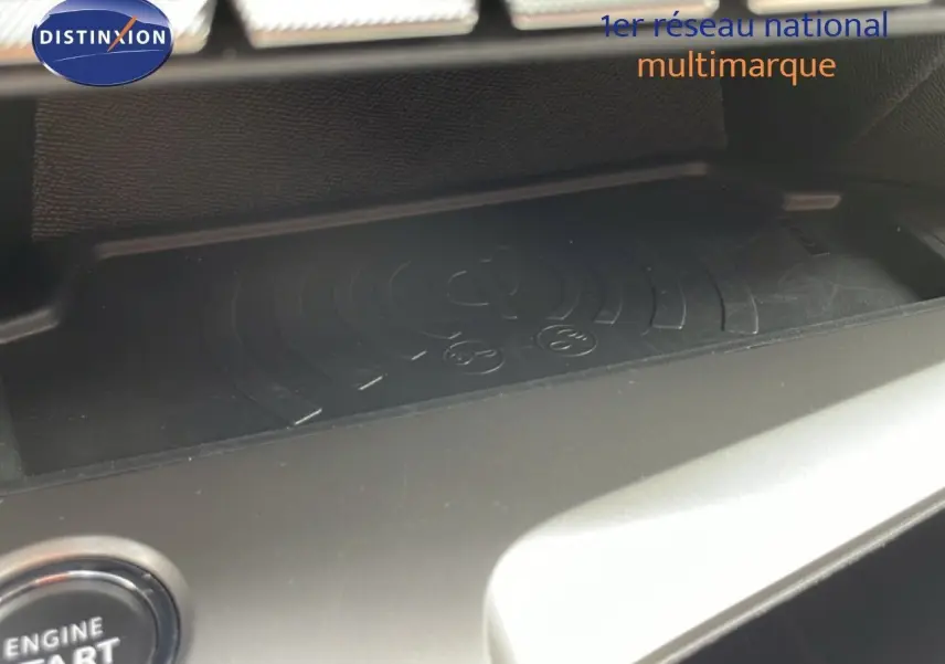 Détail du compartiment intérieur avec surface de charge sans fil dans une Peugeot 308 SW noir métal, vue rapprochée.