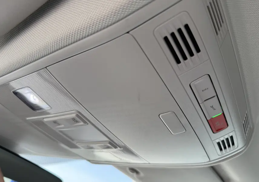 Plafonnier intérieur gris clair du Volkswagen Taigo 2022 avec boutons d’éclairage et système d’appel d’urgence visibles.