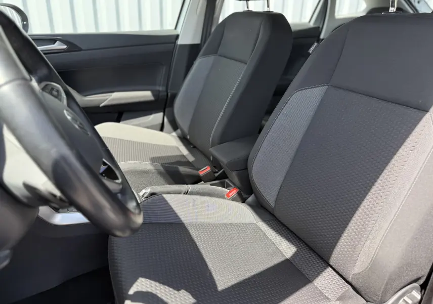 Vue rapprochée des sièges avant en tissu gris foncé du Volkswagen Taigo 2022, intérieur sobre et lumineux.