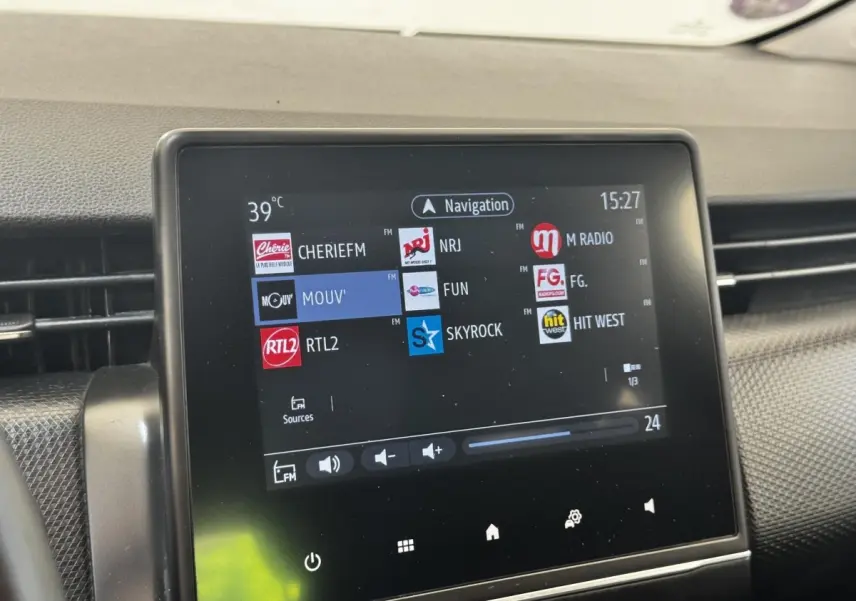 Écran tactile central de la Renault Clio Business E-TECH 140 gris clair, affichant les stations radio FM.