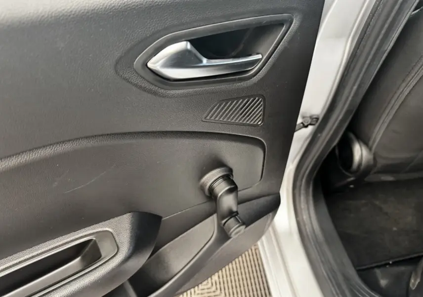 Vue rapprochée de la porte arrière droite gris clair de la Renault Clio Business E-TECH 140 avec manivelle de vitre manuelle.