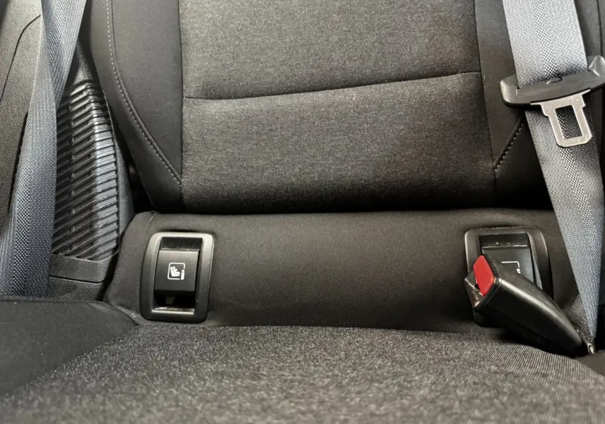 Gros plan sur la banquette arrière noire de la Renault Clio Business E-TECH 140, montrant les attaches Isofix et la ceinture de sécurité.