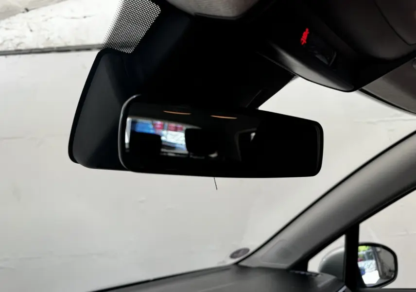 Rétroviseur intérieur de Renault Clio Business E-TECH 140 gris clair, vue centrée sur le miroir et pare-brise.