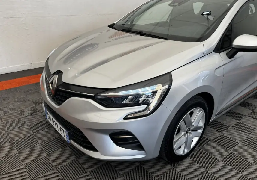 Vue 3/4 avant droite d'une Renault Clio Business E-TECH 140 gris clair avec phares LED et jantes alliage.