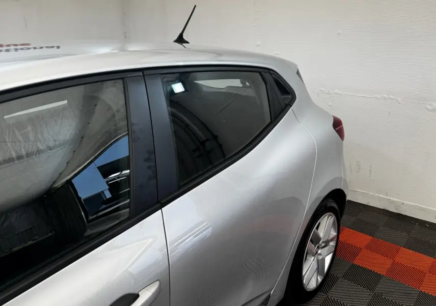 Vue côté arrière droit d'une Renault Clio Business E-TECH 140 gris clair, mettant en valeur la porte arrière et la jante alliage.