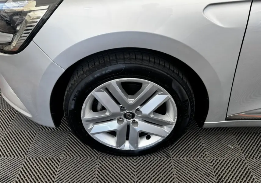 Gros plan sur la roue avant gauche gris clair de la Renault Clio Business E-TECH 140 avec jante alliage à cinq branches.