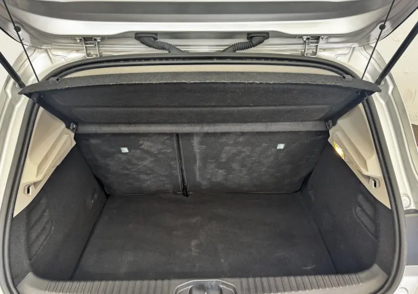 Coffre ouvert vu de l'arrière d'une Renault Clio Business E-TECH 140 gris clair, montrant l'espace de chargement vide.