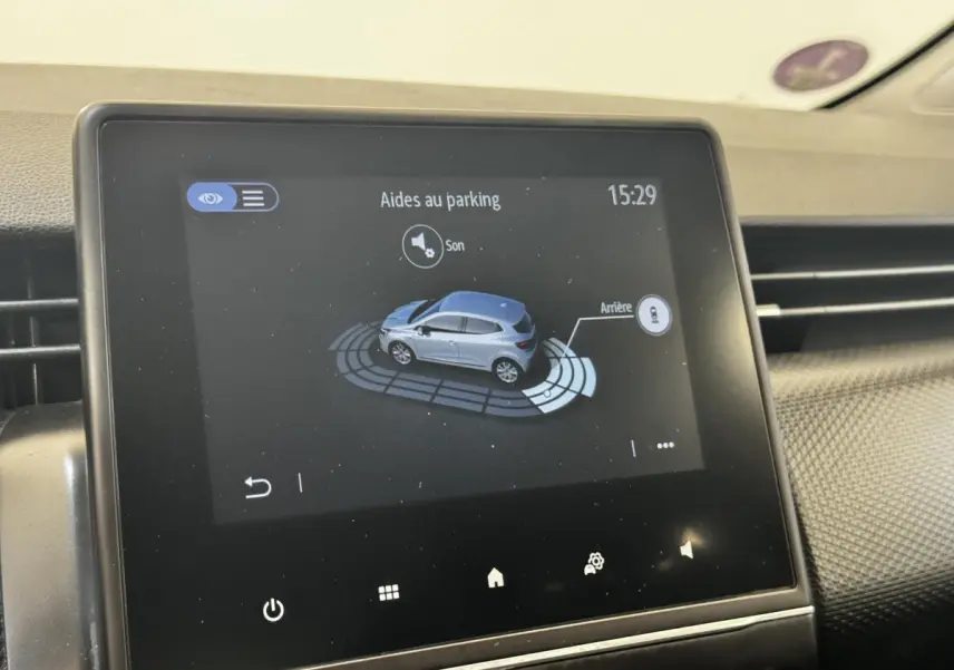 Écran tactile central montrant l’aide au parking d’une Renault Clio Business E-TECH 140 gris clair, vue intérieure.