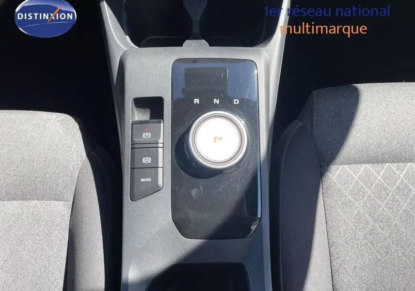 Vue plongeante sur la console centrale de la MG3 2025, avec molette de boîte auto et sièges tissu gris foncé.