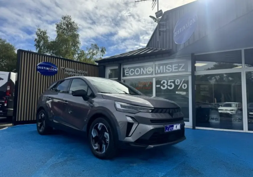Renault Symbioz 1.8 E-Tech gris Cassiopée métallisé en 3/4 avant droit, avec jantes alu et calandre noire distinctive.