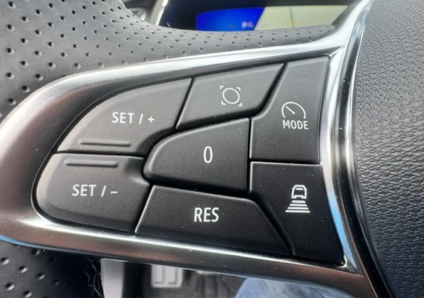 Gros plan sur les commandes noires du volant multifonction du Renault Symbioz gris Cassiopée métallisé.