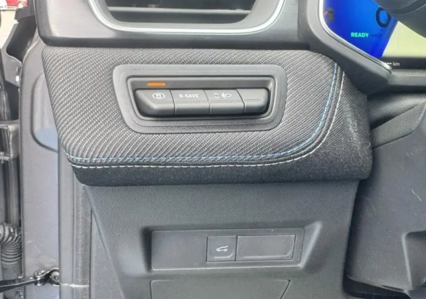 Détail des commandes E-SAVE et éclairage sur la planche de bord côté gauche d’un Renault Symbioz gris Cassiopée.