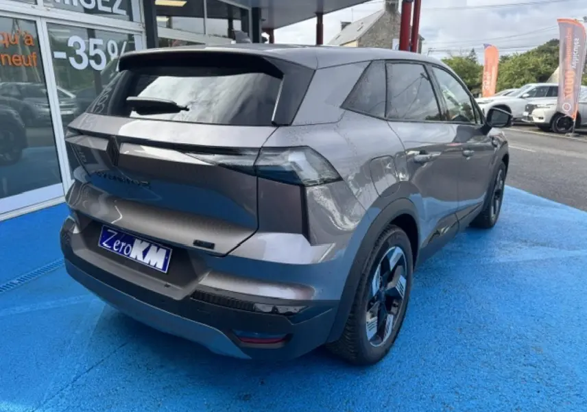 Vue 3/4 arrière droite du Renault Symbioz 2026 gris Cassiopée métallisé avec feux arrière LED et jantes alu noires.