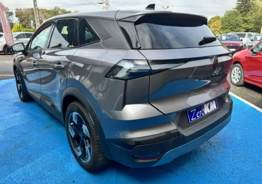 Vue 3/4 arrière droite d'un Renault Symbioz gris Cassiopée métallisé avec becquet et feux arrière LED distinctifs.